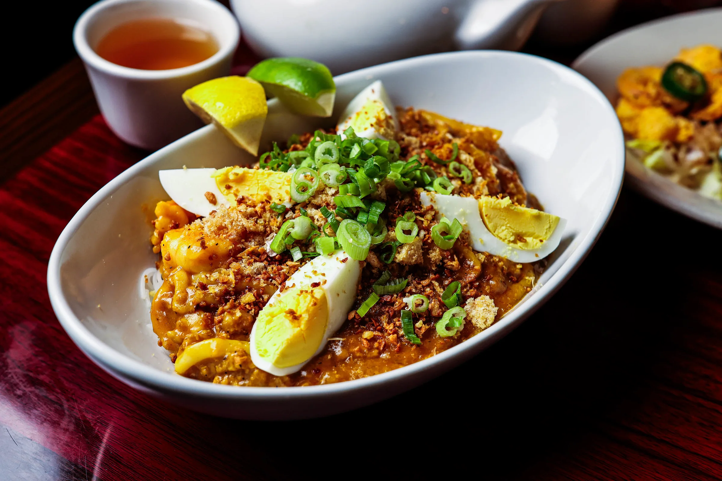Pancit palabok topped with egg, shrimp and calamansi